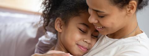 Woman and child embracing on a couch