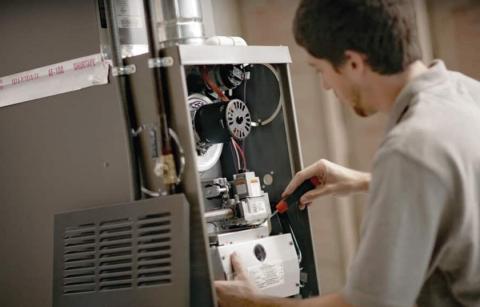 A technician examining a residential furnace.
